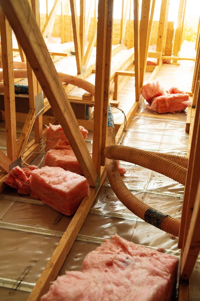Blown-in hoses and fresh insulation in an attic during an Eco upgrade
