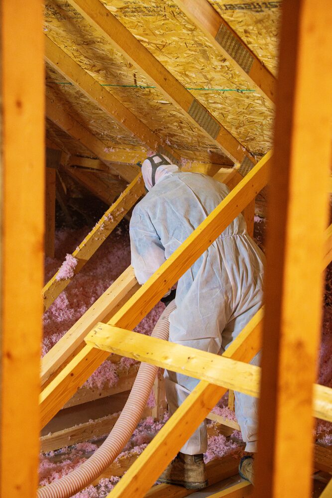 Eco Insulation installer blowing insulation into an attic